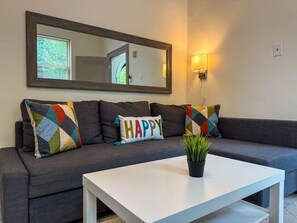The living room’s cozy vibe makes it the perfect spot to relax, with ample seating and a warm ambiance.