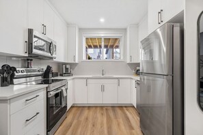 Full kitchen with a blender, crockpot, rice cooker, hand mixer, and drip & Keurig coffee makers.