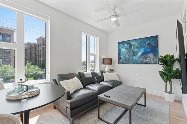 Beautifully designed living room. 65" TV, leather sofa and amazing views of mountains and city skyline.