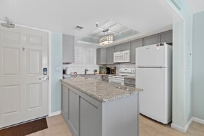 Cook in style with granite countertops, sleek appliances, and ample storage in this bright, functional kitchen.