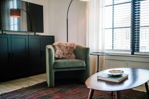 Step into a warm and welcoming living room, perfect for unwinding after a day of exploring. This space features a comfortable sofa where you can stretch out and relax. Whether you're looking to catch up on your favorite series on our large-screen TV or simply have a quiet night in, this room is designed for ultimate comfort and entertainment. Make yourself at home!