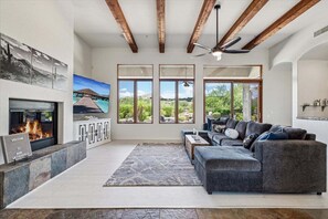 Main Living room featuring plenty of seating, gas fireplace, smart TV, Dining Table and access to the backyard.
