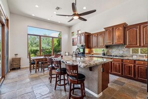Stunning and fully equipped kitchen with stainless steel appliances and a dining table.