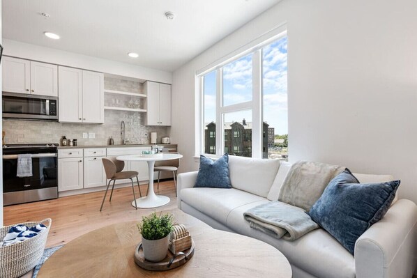 Beautifully designed living room. 65" TV, leather sofa and amazing views of mountains and city skyline.
