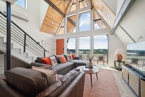 Open-concept living area w/ sleeper couch (Queen bed) and smart TV