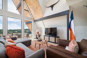 Open-concept living area w/ sleeper couch (Queen bed) and smart TV