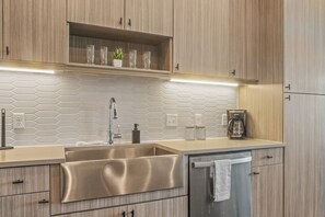 This contemporary kitchen is a chef's dream, featuring a large island, modern stainless steel appliances, and sleek cabinetry. The open layout ensures you can cook and entertain effortlessly, making it the perfect space for culinary creativity and social