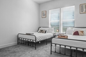 Rest comfortably in this spacious bedroom featuring two cozy queen beds, stylish decor, and plenty of natural light. Perfect for families or friends traveling together.