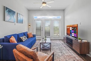 Bright and airy living room with plush seating, a large TV, and tasteful decor, creating the perfect space for relaxation and entertainment.