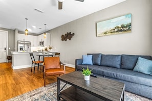 Bright and airy living room with plush seating, a large TV, and tasteful decor, creating the perfect space for relaxation and entertainment.