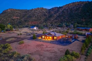 1 acre Lot and exterior at dusk. With hot tub, walking labyrinth, sauna and fire pit.