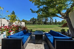 Back patio seating with fire pit and golf course views