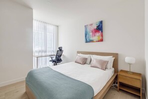 The light and bright second bedroom highlights a queen-sized bed and also benefits from a dedicated workspace.
