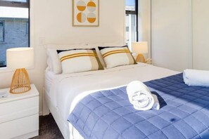 Comfortable bed with side lampshades with hotel quality towels