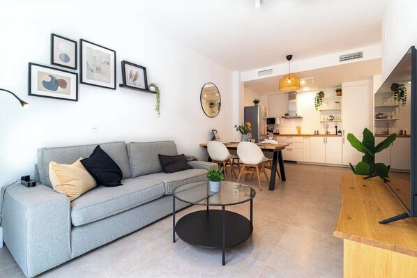 Salón, mesa de comedor y cocina abierta