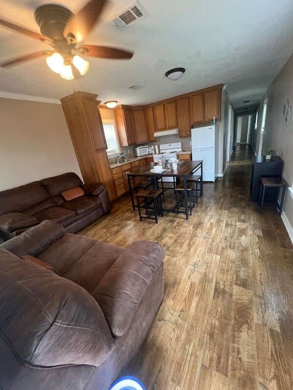 Living room with kitchen and flat screen smart TV.