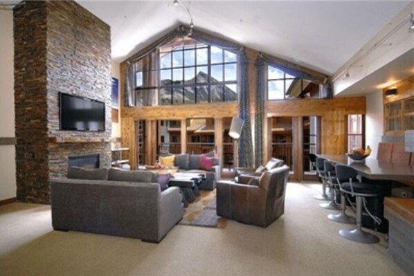 Grand living room with floor-to-ceiling windows and luxurious seating, perfect for relaxation.