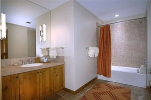 Spacious bathroom with a relaxing bathtub and elegant finishes.