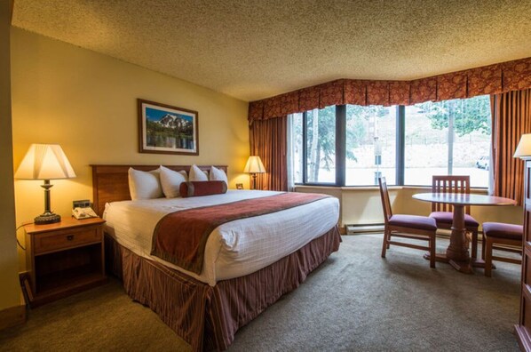 Comfortable bedroom with large windows and a serene view, perfect for unwinding.