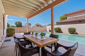 Patio: Covered patio with outdoor dining and seating next to the pool
