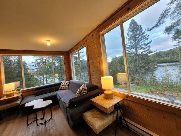 Corner of enclosed porch with dramatic lake view; lots of room to relax