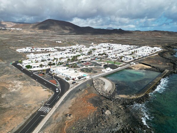 Vista Aérea junto a la Piscina Natural en La Urbanización Los Cocoteros Bayside Kalendra - Jable: Un Retiro Escondido Junto al Mar