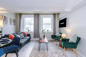 The open-plan living room and dining area benefit from a 50-inch Smart TV, a 4-seater dining table,  a 3-seater breakfast bar, plenty of space to sit down in the evenings and a double sofa bed.