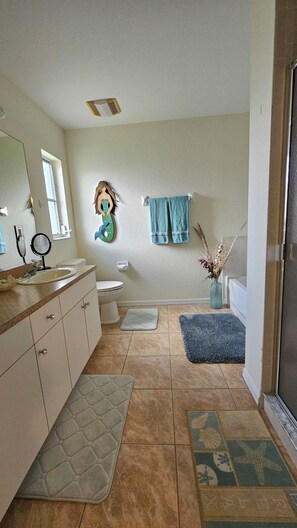 Bathroom in main bedroom with tub and separate shower.