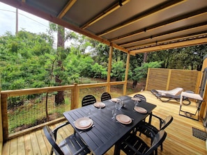 Relax on the covered patio with a plancha grill, perfect for alfresco dining. The spacious table comfortably seats six, surrounded by nature for a serene outdoor experience.