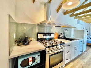 Full kitchen with stove, oven, microwave, fridge, and coffee nook
