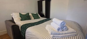 Living Room/Bedroom 3: Fully furnished with a very comfortable double-size sofa bed, wardrobe, dining table with chairs, smart TV and stand, plus gaming appliances. Perfect for relaxation and entertainment