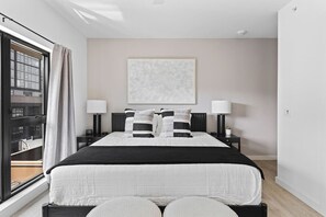 Spacious loft bedroom with a plush King bed, room-darkening shades, dresser, large closet, and ceiling fan.