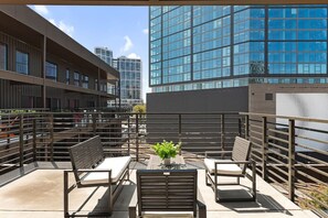 Spacious private patio with views of the city and plenty of seating.