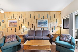 Living room featuring a queen size sleeper sofa, flat screen TV, and balcony access to incredible mountain views.