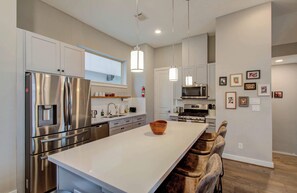 Featuring a kitchen island with stool seating for 4, this fully equipped kitchen includes a coffee machine, toaster, and kettle to ensure you start every day off on the right foot.
