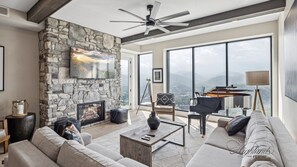 One Bedroom Mountain View Gatlinburg Vacation Condo Rental Highl - Spacious and Scenic Living Room with Stone Fireplace, Floor to Ceiling Windows with Smoky Mountain View, Smart TV's and WiFi throughout vacation condo
