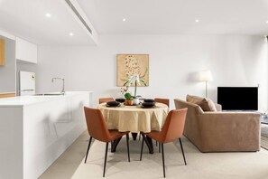 The living and dining rooms are bright and open-plan, with a dining table to enjoy a meal at home.