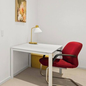 In the living area, a dedicated workspace caters to those needing to set up their laptop with a proper desk and chair.
