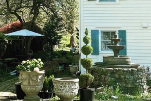water fountain and topiary plants by kitchen entrance
