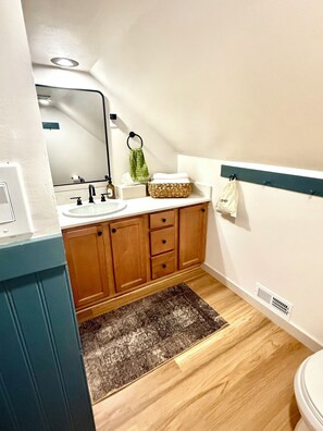 Full bathroom with hairdryer, towels, shampoo products, first aid kit, etc.