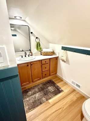 Full bathroom with hairdryer, towels, shampoo products, first aid kit, etc.