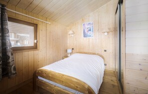 Charming bedroom with a rustic wood finish, offering a peaceful retreat.