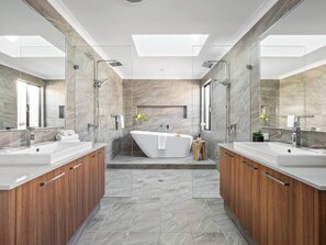 Enjoy five-star comfort in the spectacular ensuite, featuring twin rainfall showers, dual vanities and a soaking tub with serene skylit views.