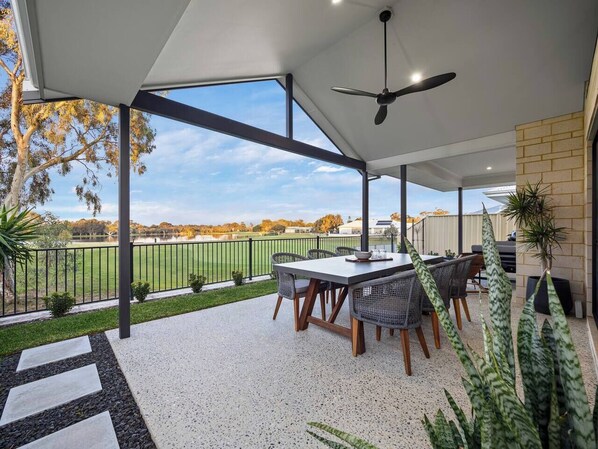 Dine outdoors in style with golf course views, ceiling fans, and fresh air—this covered alfresco is perfect for lazy breakfasts or BBQ evenings.