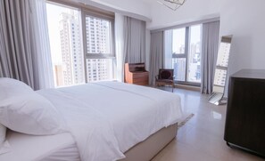 Wake up to breathtaking views from this spacious master bedroom featuring floor-to-ceiling windows and a plush king-sized bed.