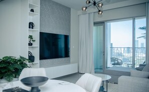 Modern living room with a large flat-screen TV and access to the balcony.