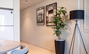 A stylish hallway featuring framed wall art and a large potted plant, creating a welcoming entrance.