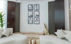 Elegant communal lounge with modern art and comfortable white seating.