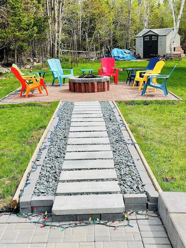 The backyard is an outdoor oasis featuring a large fire pit and a spacious lawn for hours of fun.