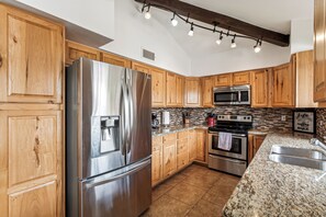 Well-equipped kitchen with stainless steel appliances and warm wood cabinetry.